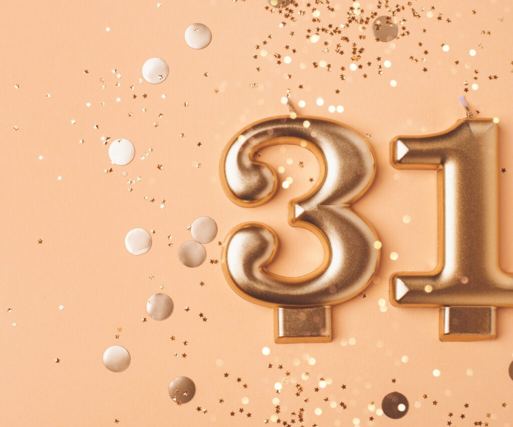 Auf dem Bild sieht man die Kerzenzahlen 31 und goldenes Konfetti